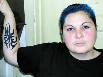 [Rebecca Breksa with blue hair and tattoo on forearm]
