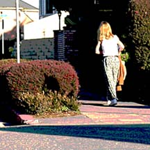 [woman walking on sidewalk]