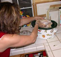 [Photo of Joan putting whole chicken in crock pot]