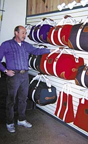 Grundman standing in front of canvas bag display in store.