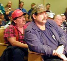 loggers wearing hats and work clothes, sitting in chambers.