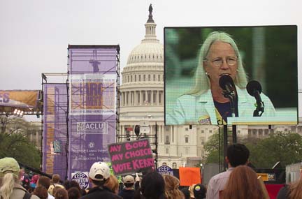 [crowd in front of capitol, big screen showing Dr. Wicklund speaking]