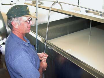 [photo of Dave Petersen in front of milk vat]