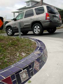 Edge of tiled round-about, with vehicle in background