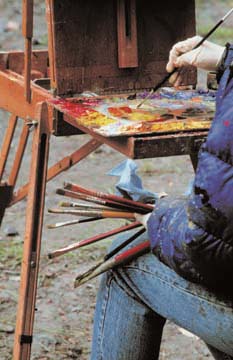 [Terry holding brushes, an dabbing paint from pallet on easel]