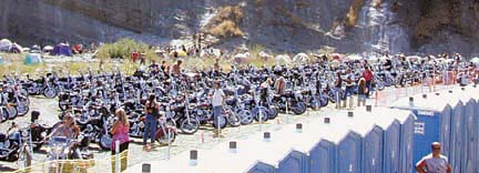 Crowd of bikers on Eel River, with outhouses in foreground