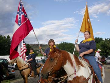 [woman on horseback with confederate flag, other woman on horse with other fmag]