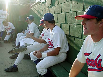 players on bench in dugout
