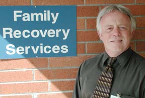 Mike Goldsby standing in front of sign for Family Recovery Services