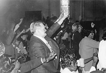 church service showing members with arms raised
