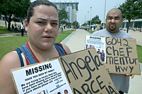 Family members carry signs outside the Houston Astrodome shelter looking for lost relatives. Photo by Andrea Booher/FEMA.