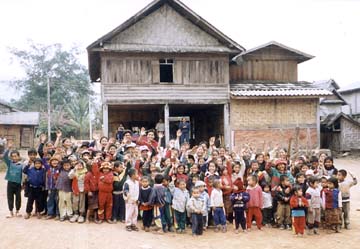 [group of schoolchildren standing in front of buildings in town]