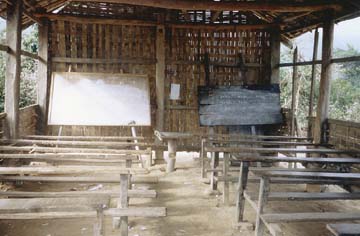 [old school classroom with benches and chalkboards on stands, stick and pole construction