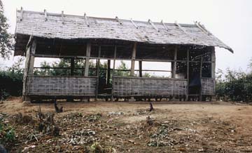 [old school house constructed with poles and sticks, open air sides]