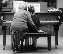 [photo of piano teacher and student]