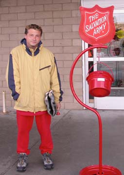 Salvation Army worker Chris Sekerak standing next to sign and donation bucket