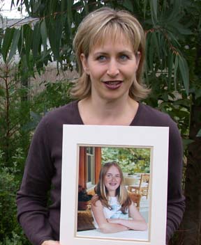 [photo of Heidi Collingwood holding photo of her late daughter]
