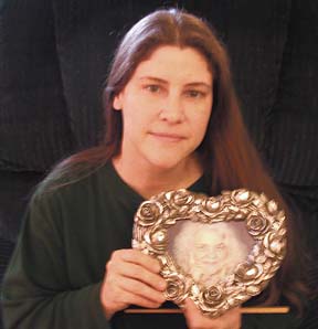 [photo of Tanya Hunt holding photo of her late mother]