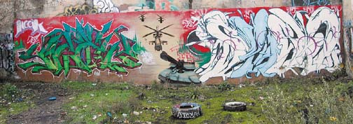 [graffiti with two tags, helicopters and tank]