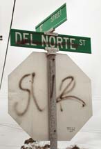 [Defaced Del Norte street sign, stop sign with "SUR" tag]