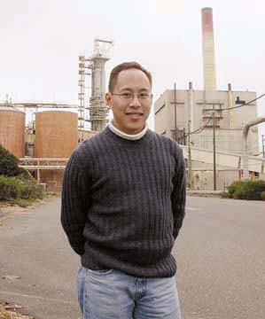 [Raymond Lee standing in front of pulp mill]