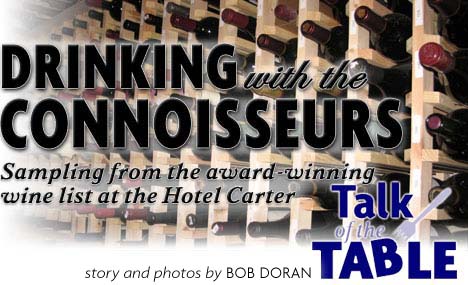 Heading: Drinking with the connoisseurs - sampling from the award-winning wine list at the Hotel Carter, photo wine bottles, photos and story by Bob Doran, Talk of the Table heading logo