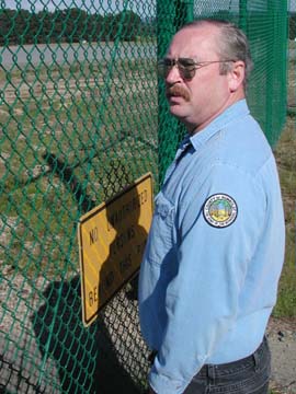 [Fritz in front of cyclone fence at airport]