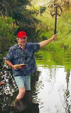 Stephen Lewis holding his sword, standing in the river