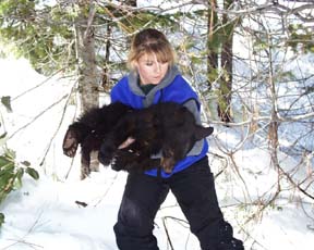 [photo of Melissa Crew with bear cub]