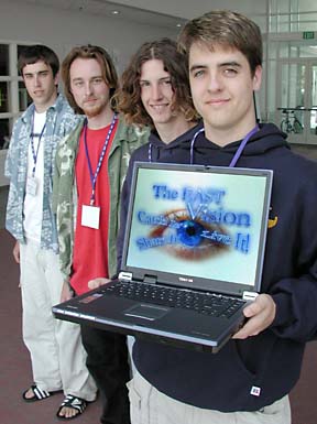 students lined up, boy holding laptop computer with EAST logo on screen