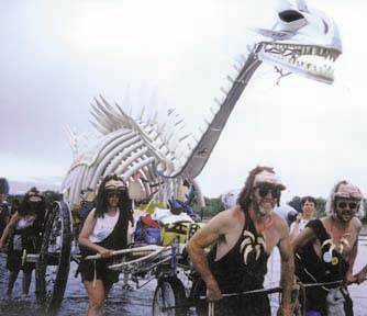 dinasaur skeleton kinetic sculpture with pilots dressed as cavemen