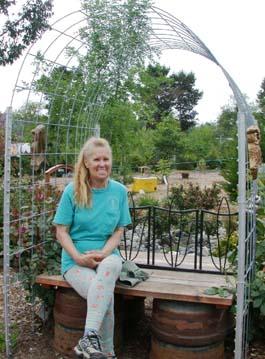 June MacDonald sitting under arch arbor in her garden