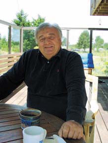 [man sitting on deck of his home]