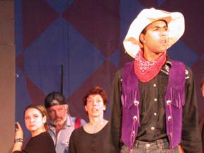 [cowboy and ensemble on stage]