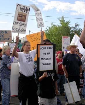[Klamath tribal members holding signs saying "C'waam, our culture depends on it" and "Don't blame the ESA for basin drought"