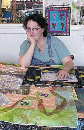 Holly Garbutt with several quilted art pieces