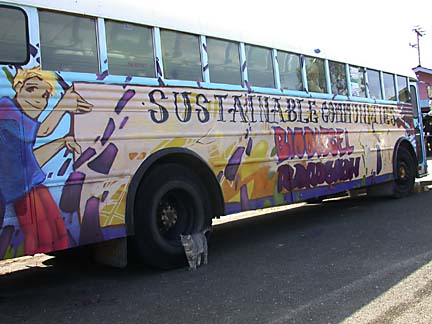 bus with paint job depicting cartoonish characters, confetti and the words "Sustainable Communities Biodiesel Roadshow"