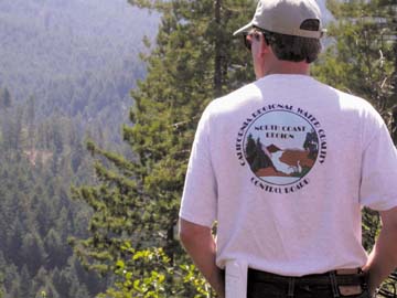 [Man looking out over forest, and wearing t-shirt reading "California Regional Water Quality Control Board, North Coast Region"]