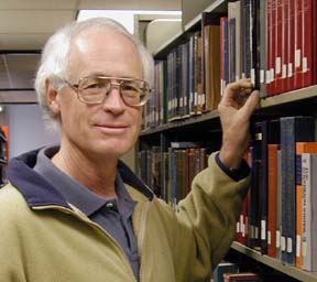 [Ray Raphael in library, standing next to bookshelves]