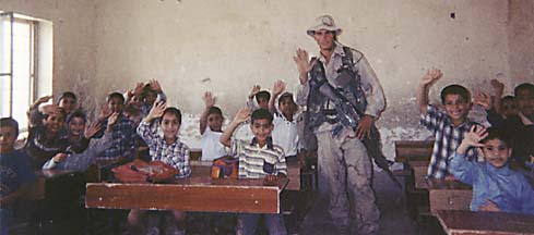 Ingram in classroom with children waving at camera
