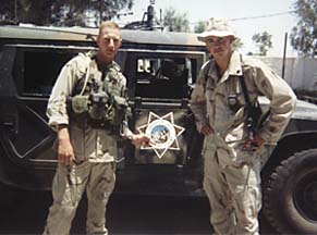 Ingram and friend stand in front of HumVee