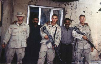 Ingram with fellow soldiers and Iraqis in front of building