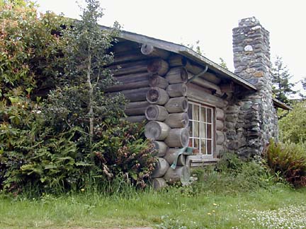 log cabin with paned window and river-rock chimney