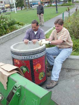 [men moving tiled trashcan into place on Arcata Plaza]