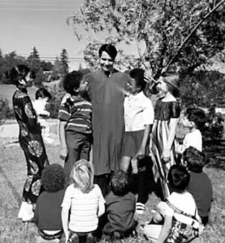 Jones in robe, surrounded by several children of different races