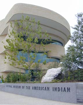 [Front of National Museum of the American Indian building with trees andn rocks landscaping]