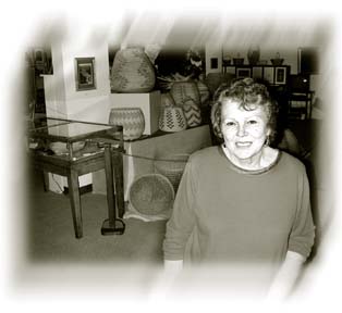 Rosemary Hunter standing in front of basket collection of the Clarke Museum