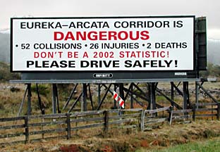 [photo of sign: "EUREKA-ARCATA CORRIDOR IS DANGEROUS - 52 COLLISIONS - 26 INJURIES - 2 DEATHS - DON'T BE A 2002 STATISTIC! PLEASE DRIVE SAFELY!]