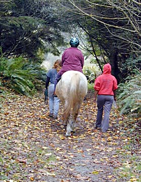 Sally Upatisringa riding horse on leaf-strewn trail
