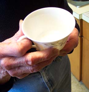 [elderly person holding cup]